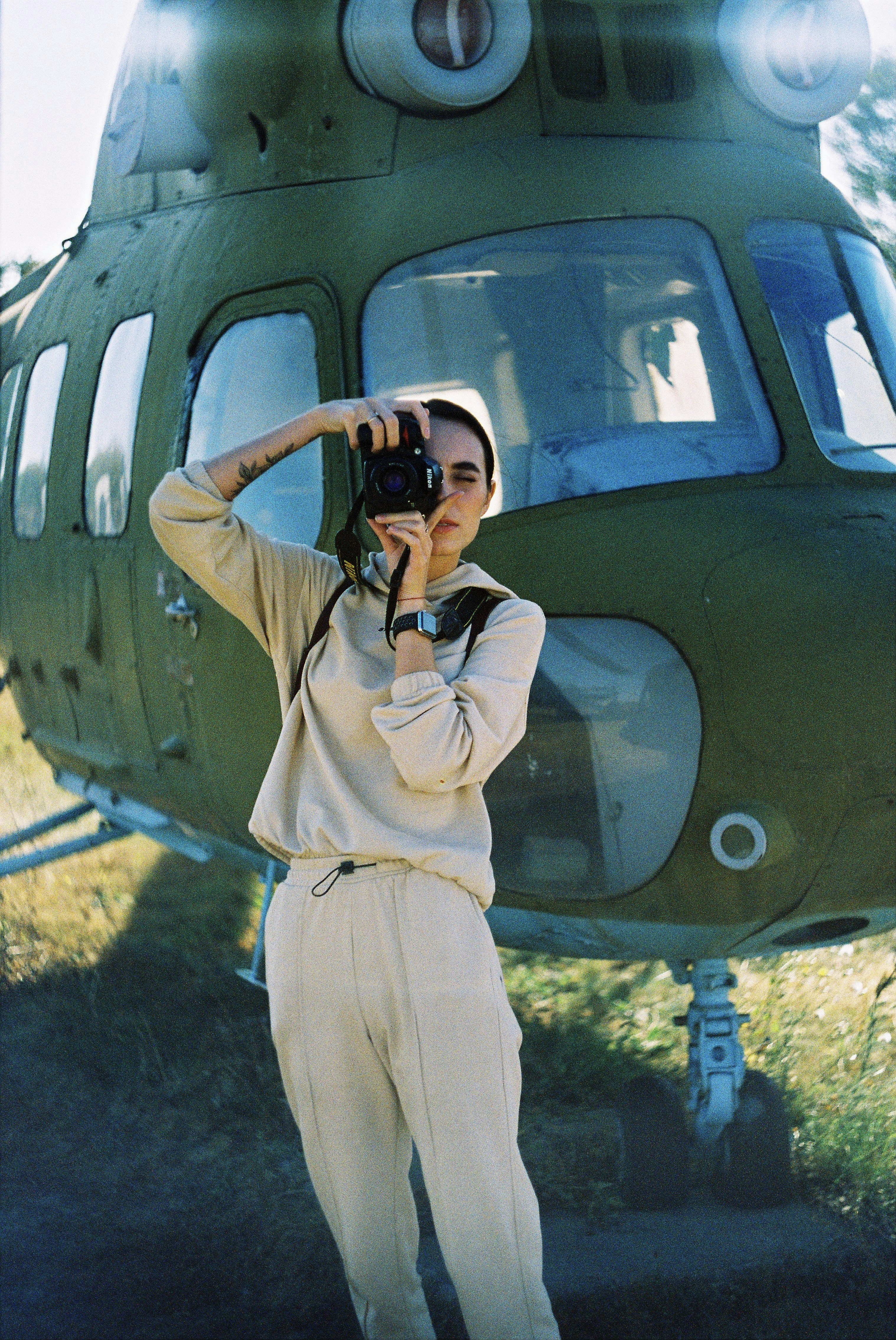 man in white jacket and pants holding black dslr camera