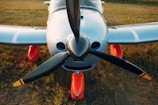 white and red airplane on brown field during daytime