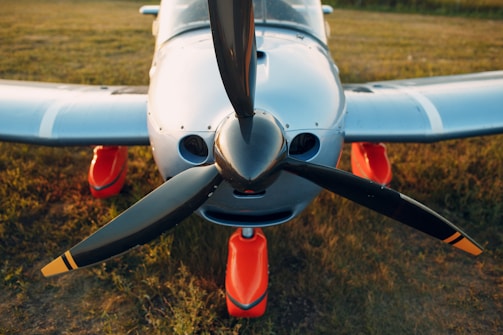 white and red airplane on brown field during daytime