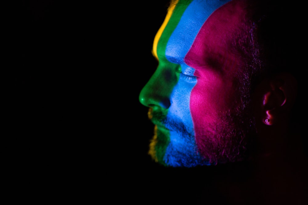 man with green blue and yellow powder on his face