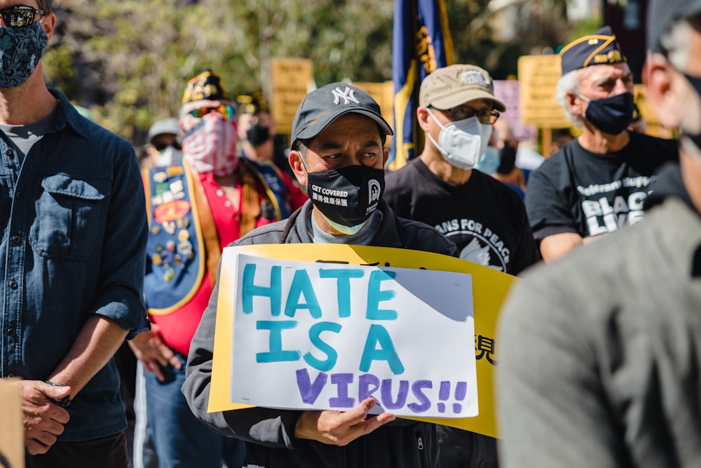 man in black jacket holding white and blue banner