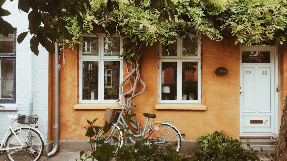 blue city bike parked beside brown concrete building