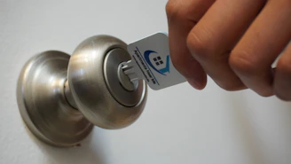 A friendly hotel receptionist handing a key card to a smiling guest at the front desk.