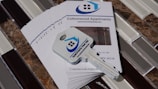 A stack of brochures for Cottonwood Apartments is placed on a tiled surface. On top of the brochures, there is a key with a logo that features a house and the words 'Apartments Near Me'. The brochures include contact information and a picture of the apartment interior.