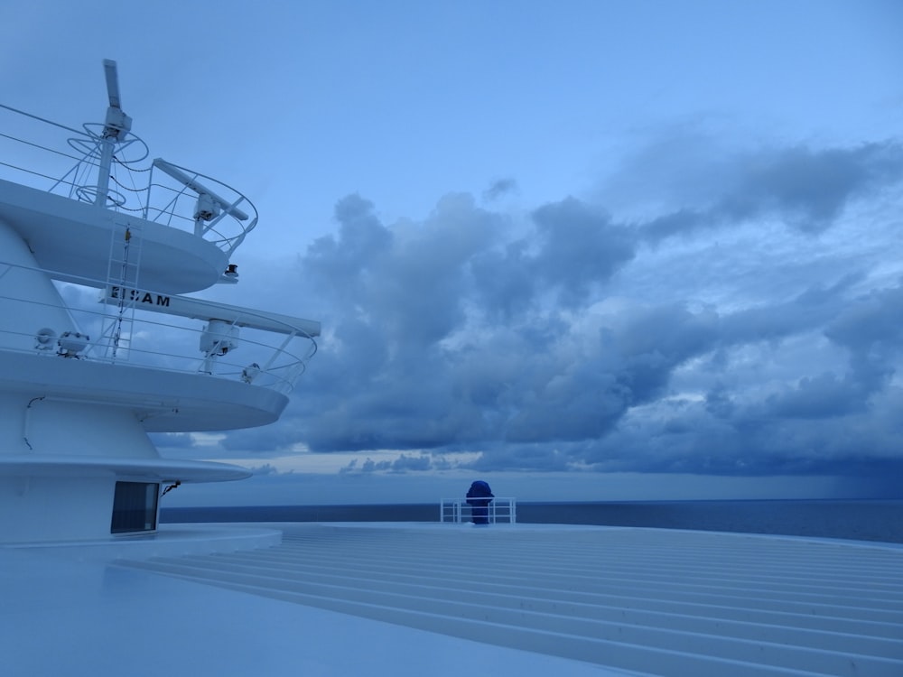 white and blue ship on sea under blue sky and white clouds during daytime