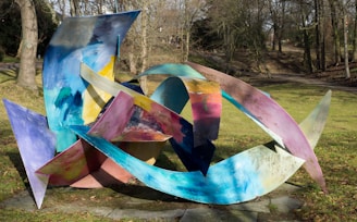 An abstract sculpture made from recycled materials in a park.