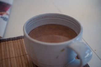 white ceramic mug on white table