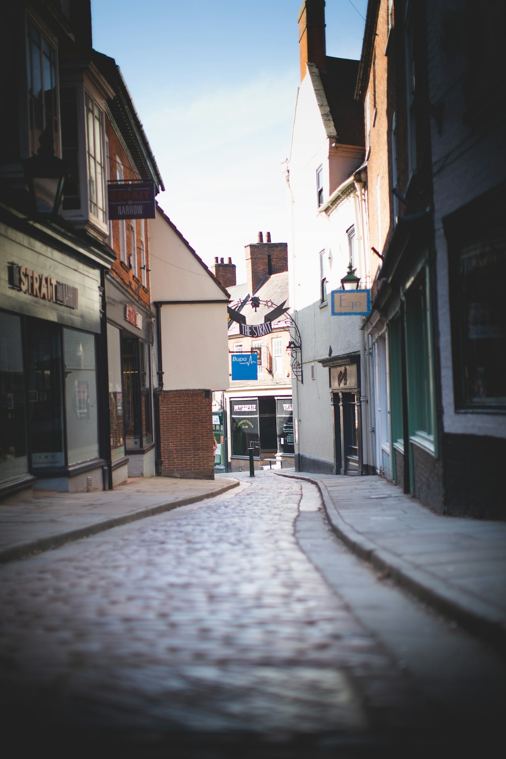 empty street in between houses during daytime