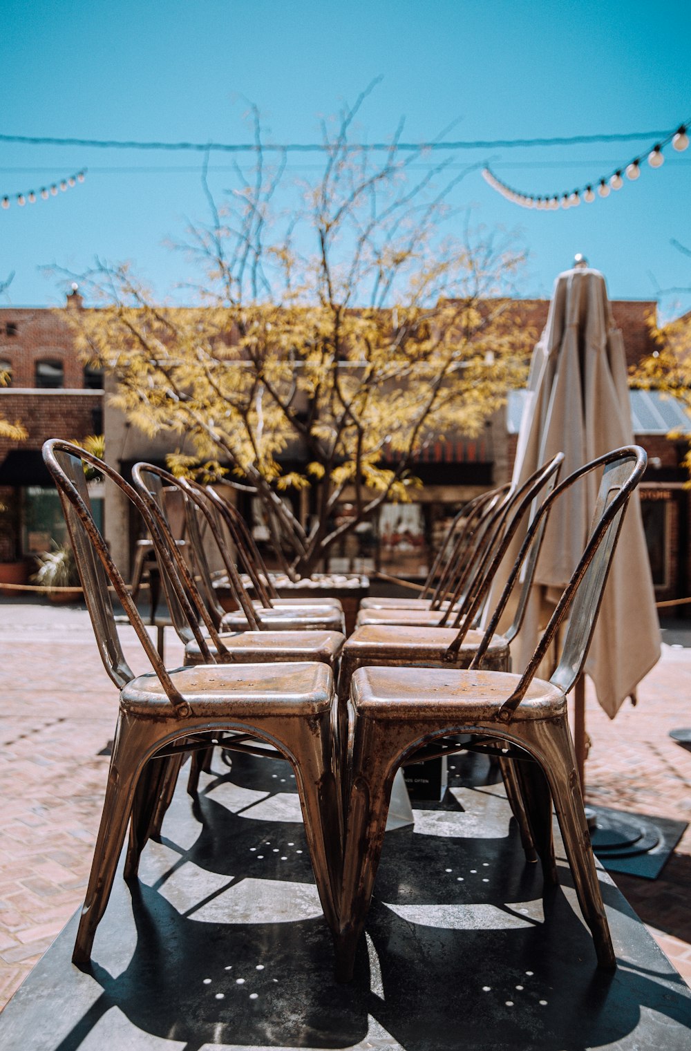 brown wooden chairs on gray concrete floor during daytime