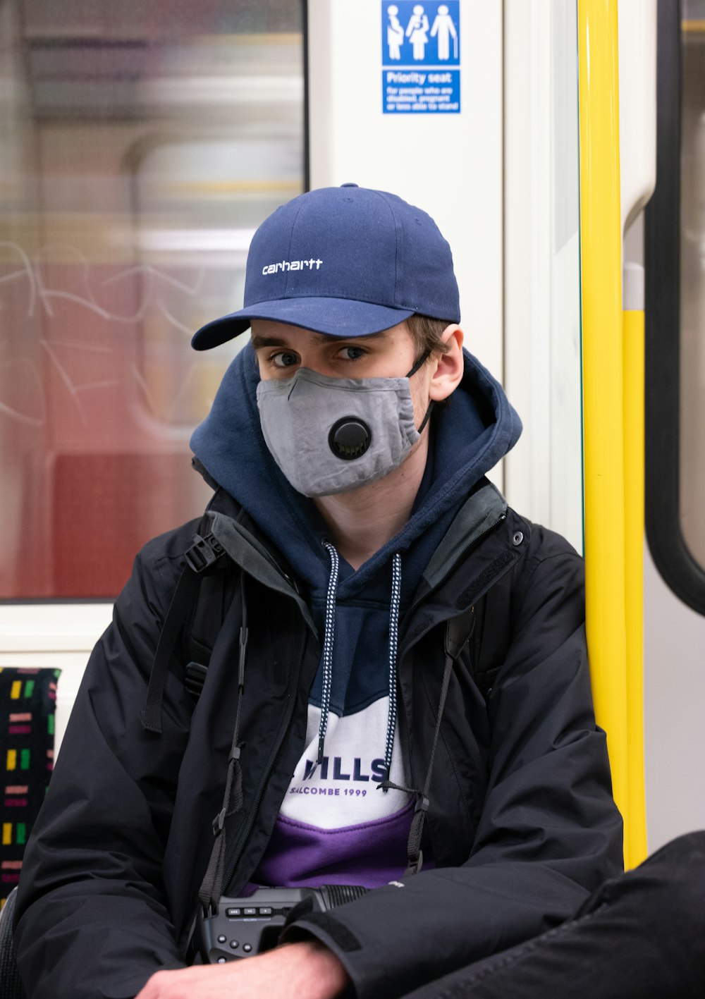 man in black zip up jacket wearing blue fitted cap