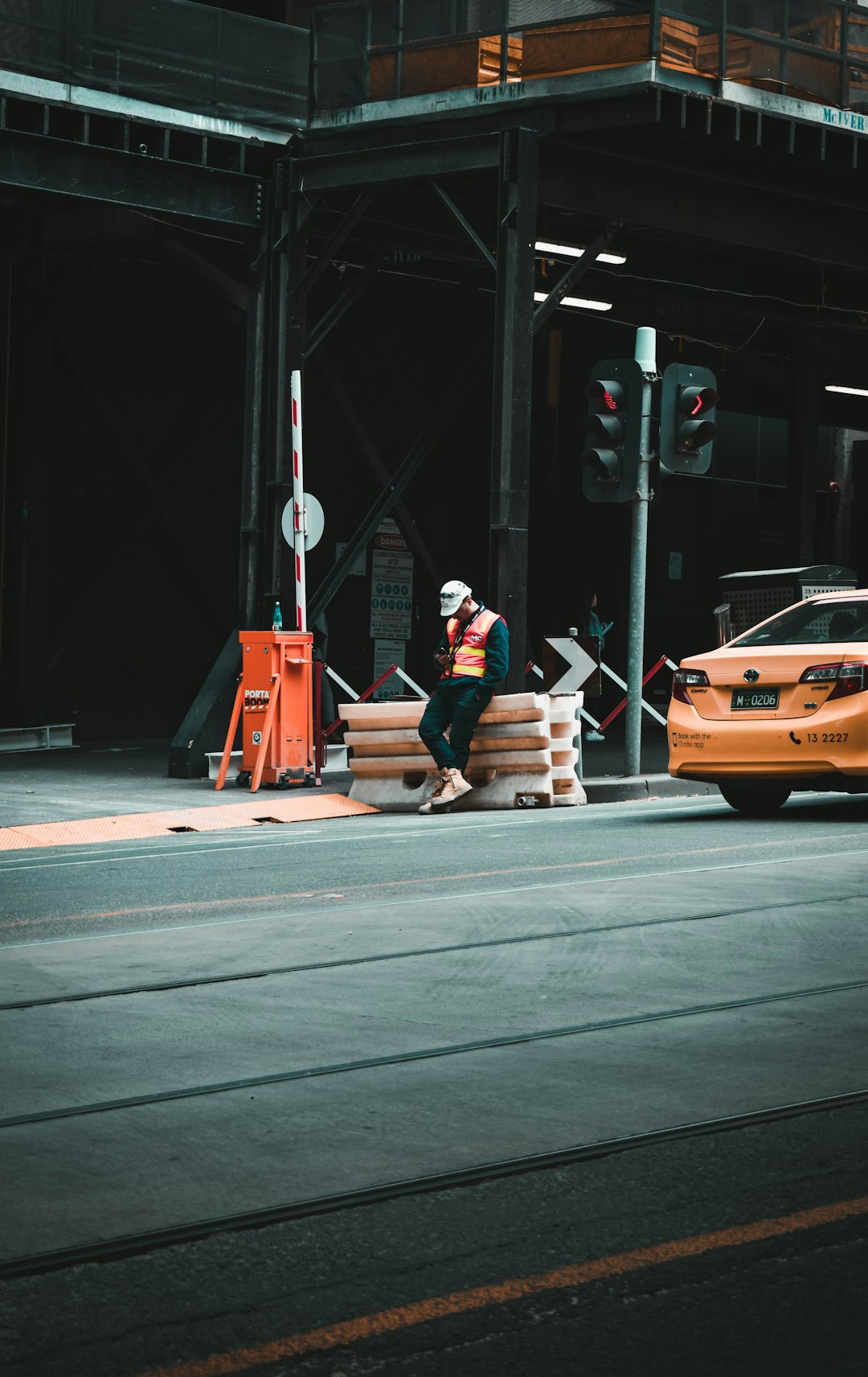 man in black jacket sitting on orange car hood during daytime