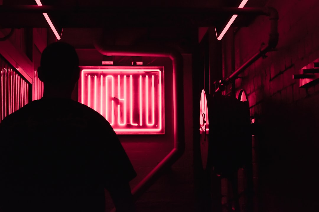 man in black shirt standing near red light