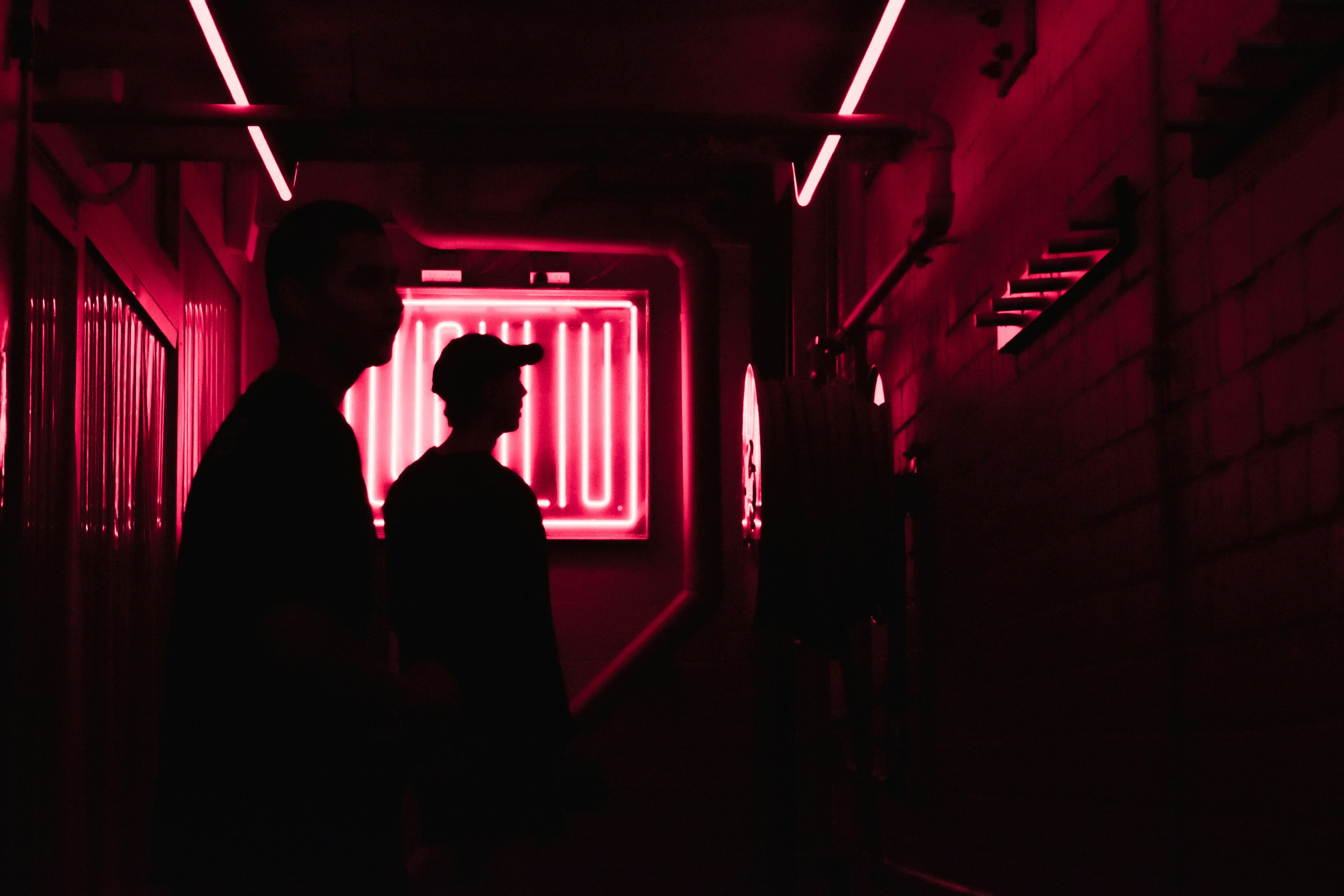 man and woman standing in front of red light