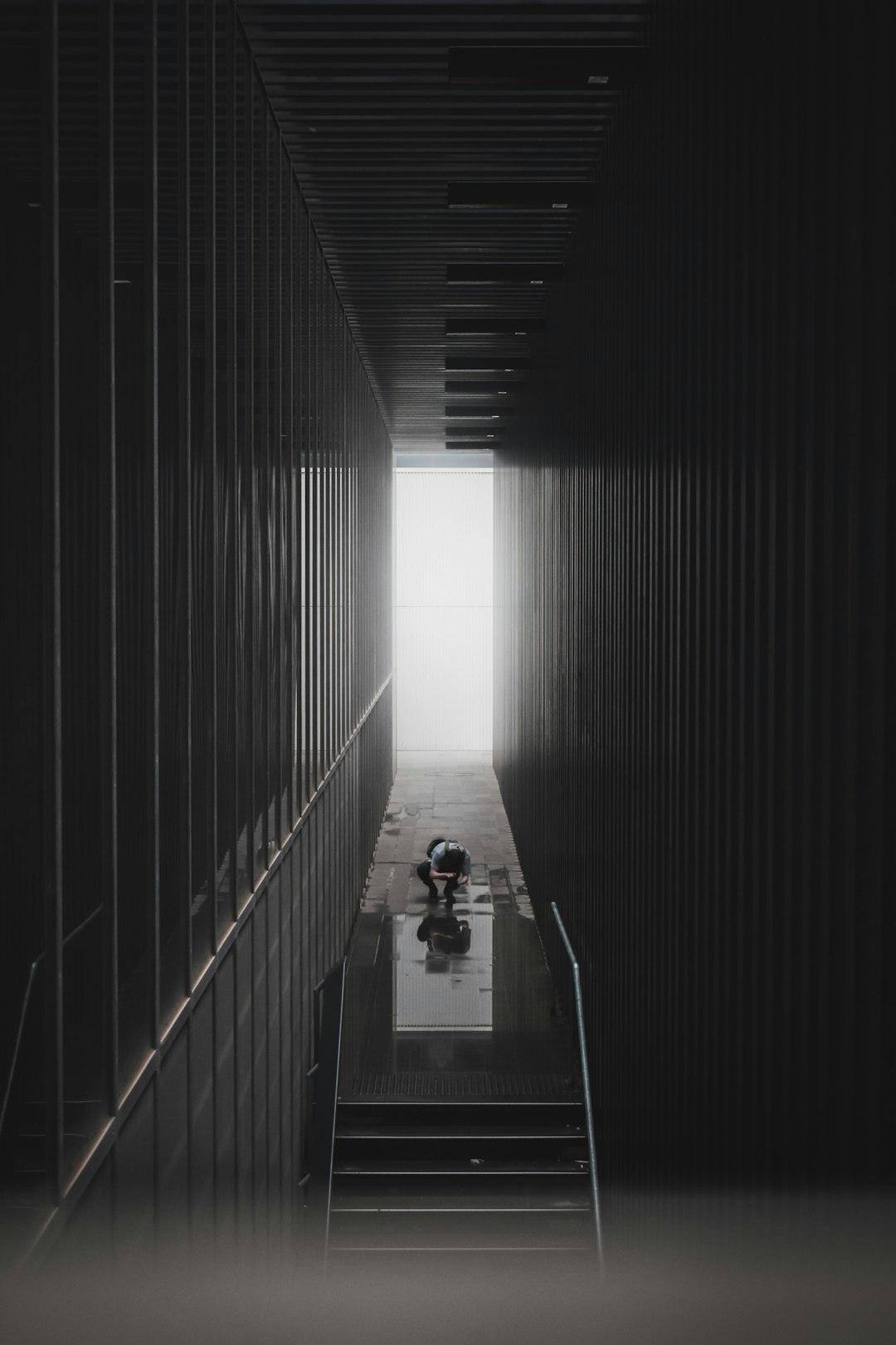 man in black shirt walking on tunnel