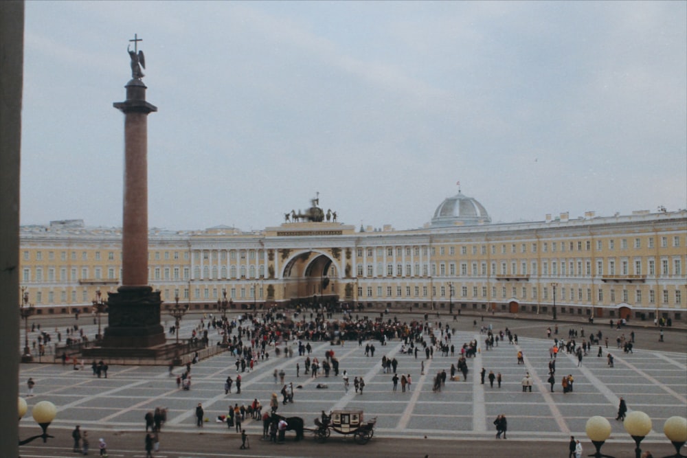 a group of people standing in a courtyard next to a tall building