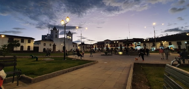 A peaceful plaza in Tlalpan at sunset, with families sitting on benches and children playing.