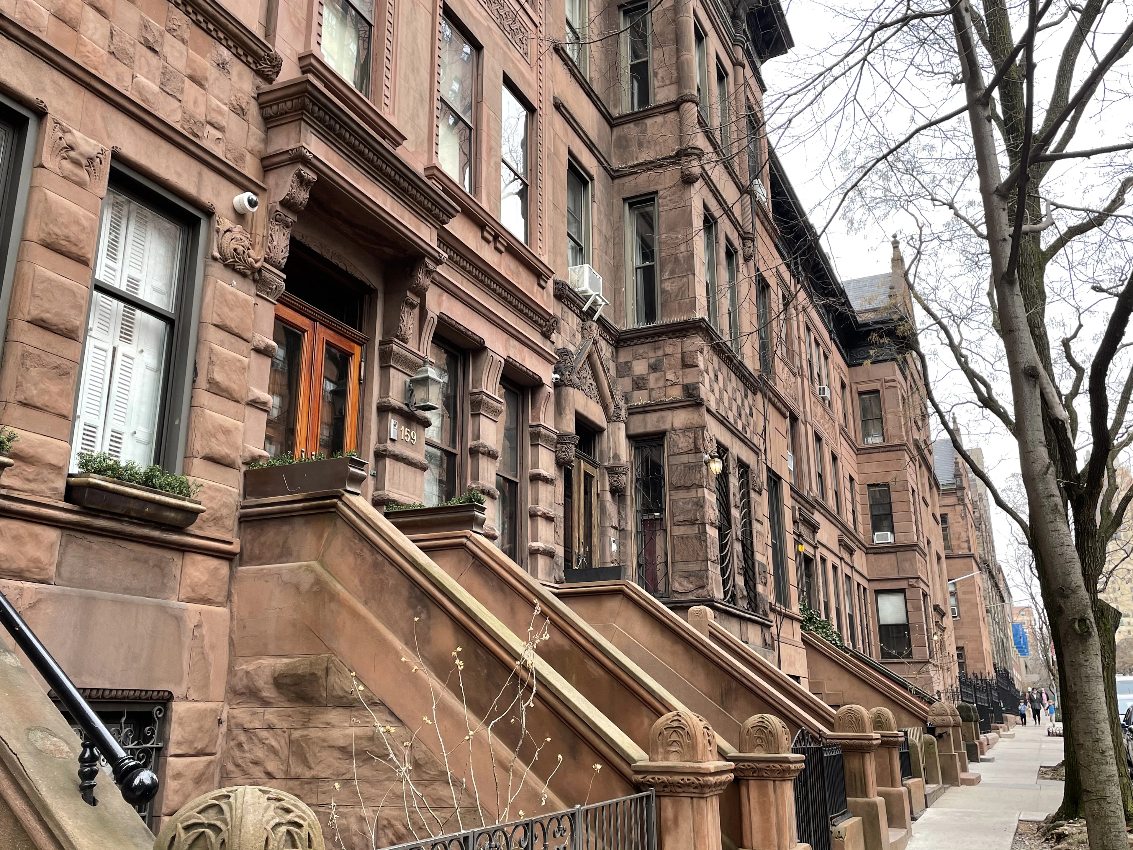 Brownstone street in winter with stoops stepping down towards the sidewalk