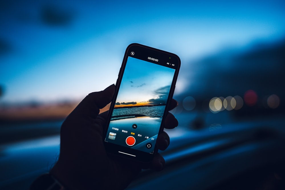 person taking photo of sunset