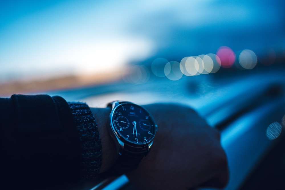 person wearing black and silver chronograph watch