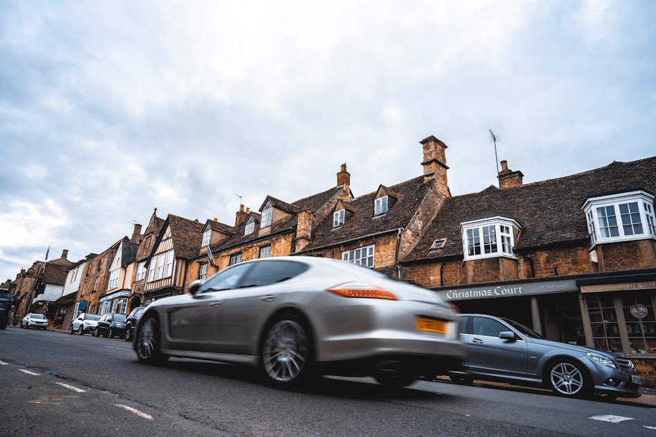 silver sedan parked beside brown concrete building during daytime