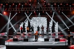 people standing on stage with lights turned on during nighttime