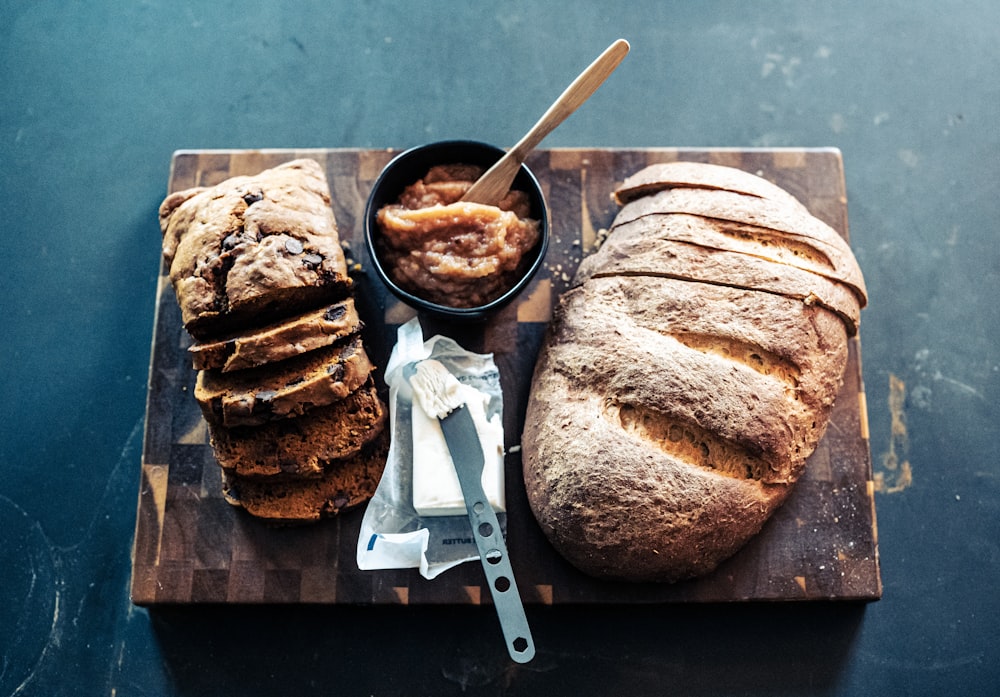 bread on black ceramic plate beside stainless steel knife