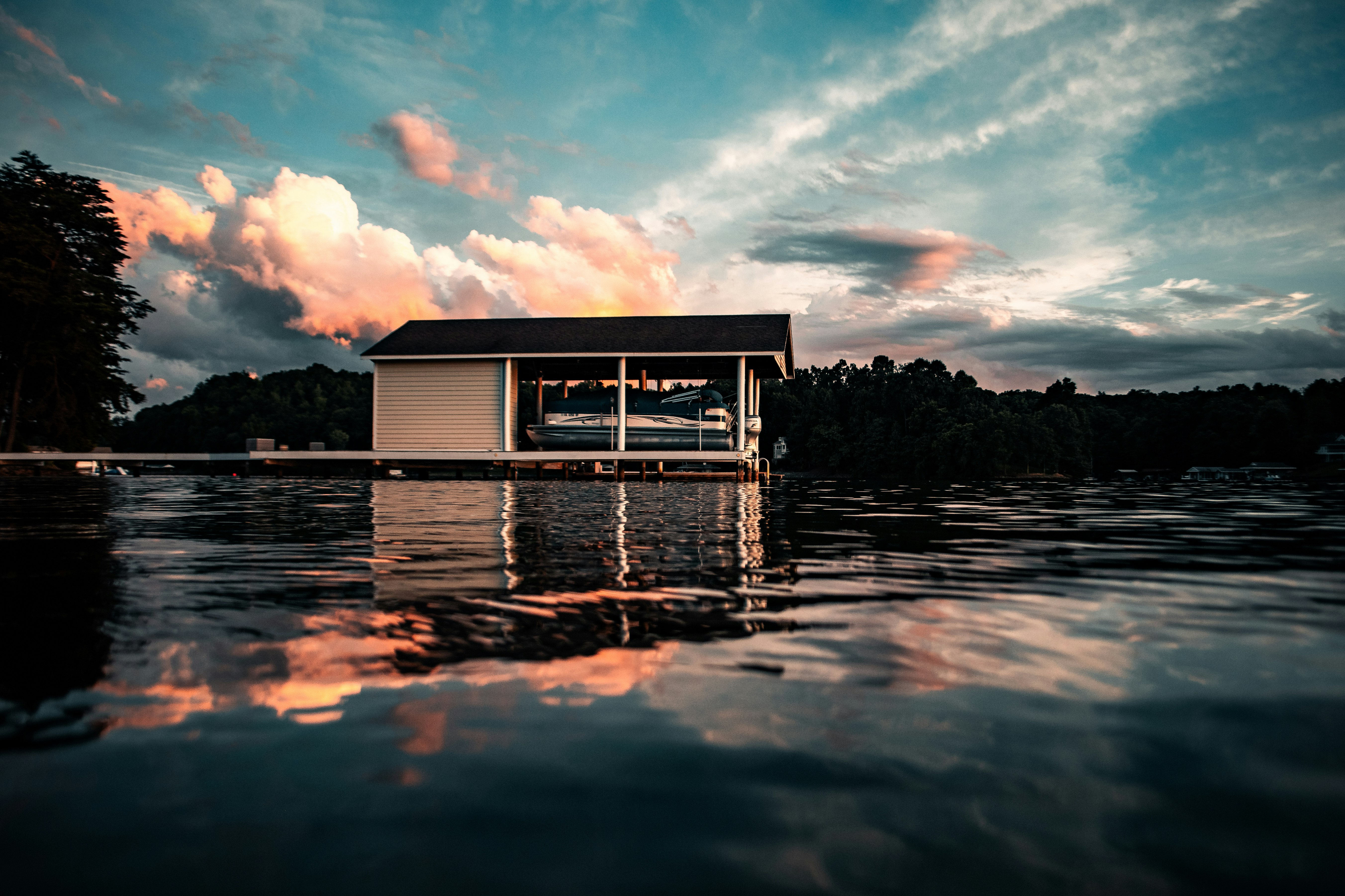 white wooden house on water under blue sky and white clouds during daytime