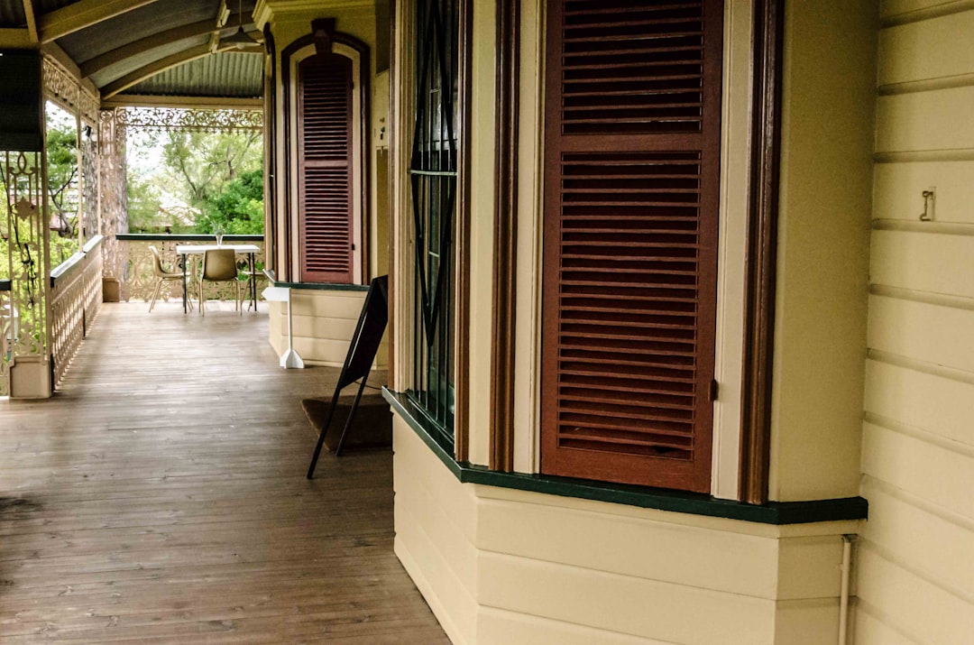  brown wooden door near white concrete wall verandah