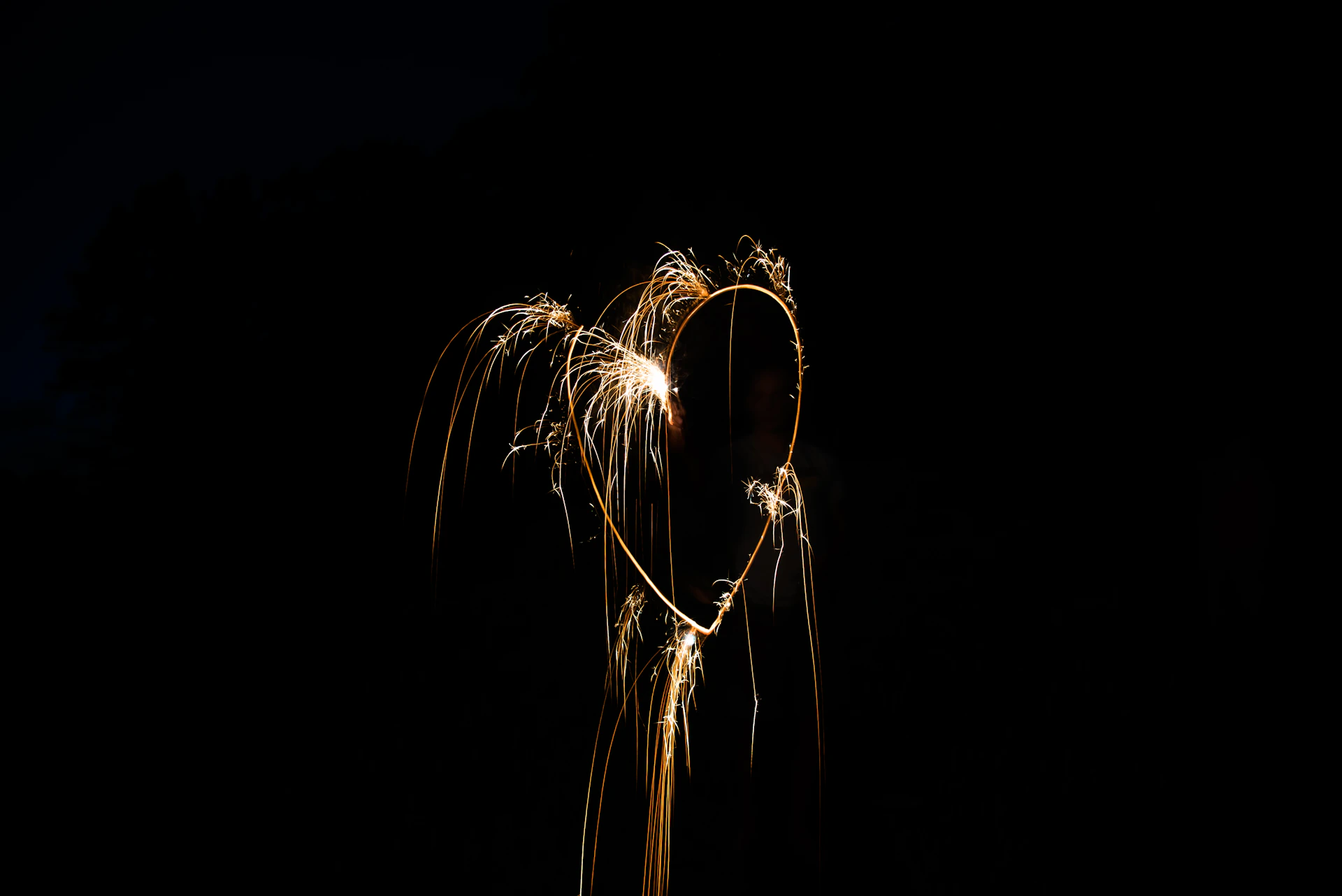 A heart-shaped arrangement of glowing fireworks bursting in the air, expressing deep affection and admiration.