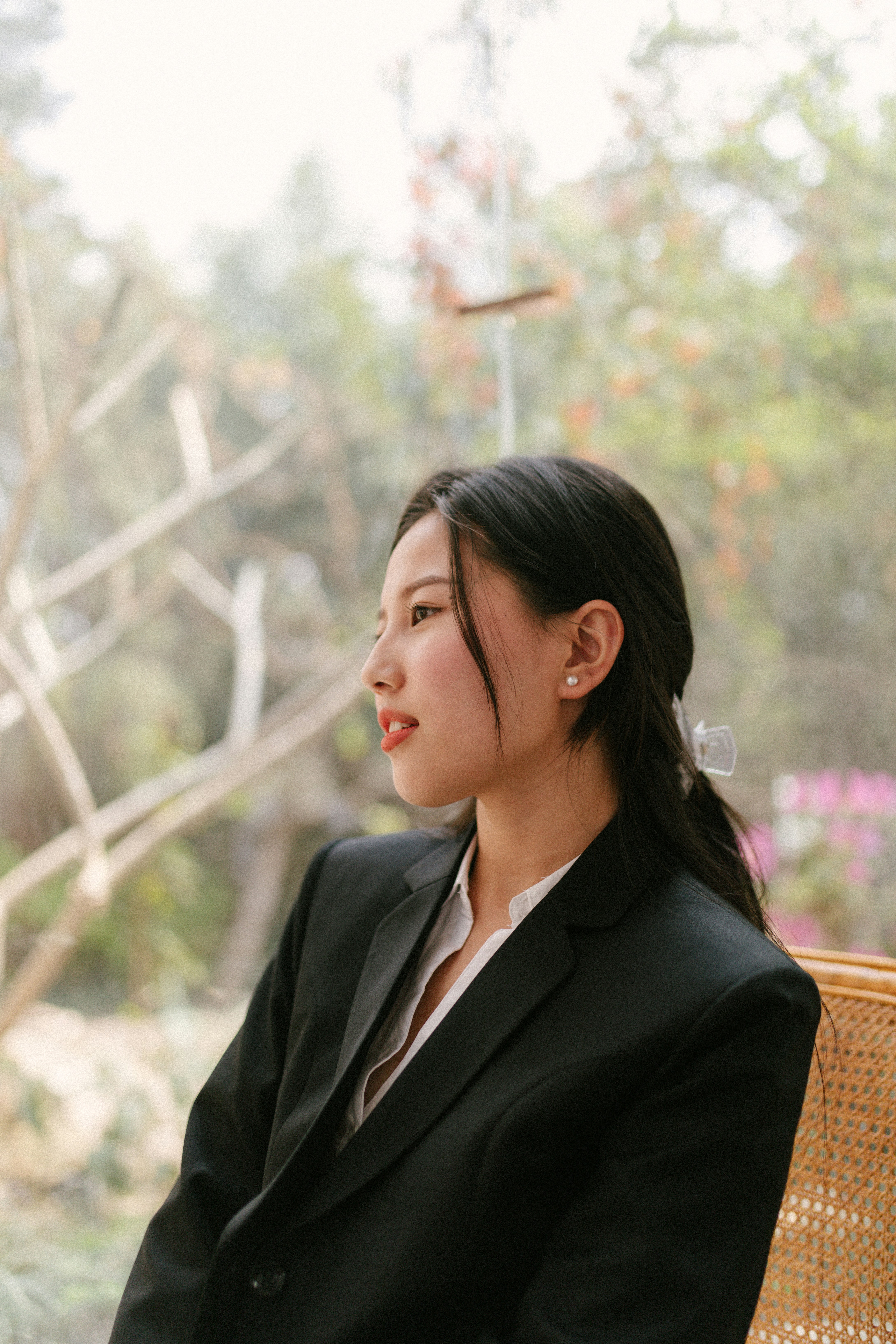 Frau im schwarzen Blazer sitzt auf braunem Holzstuhl