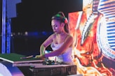 woman in green tank top wearing green headphones playing dj controller