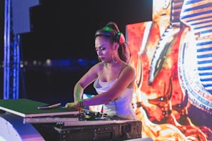 woman in green tank top wearing green headphones playing dj controller