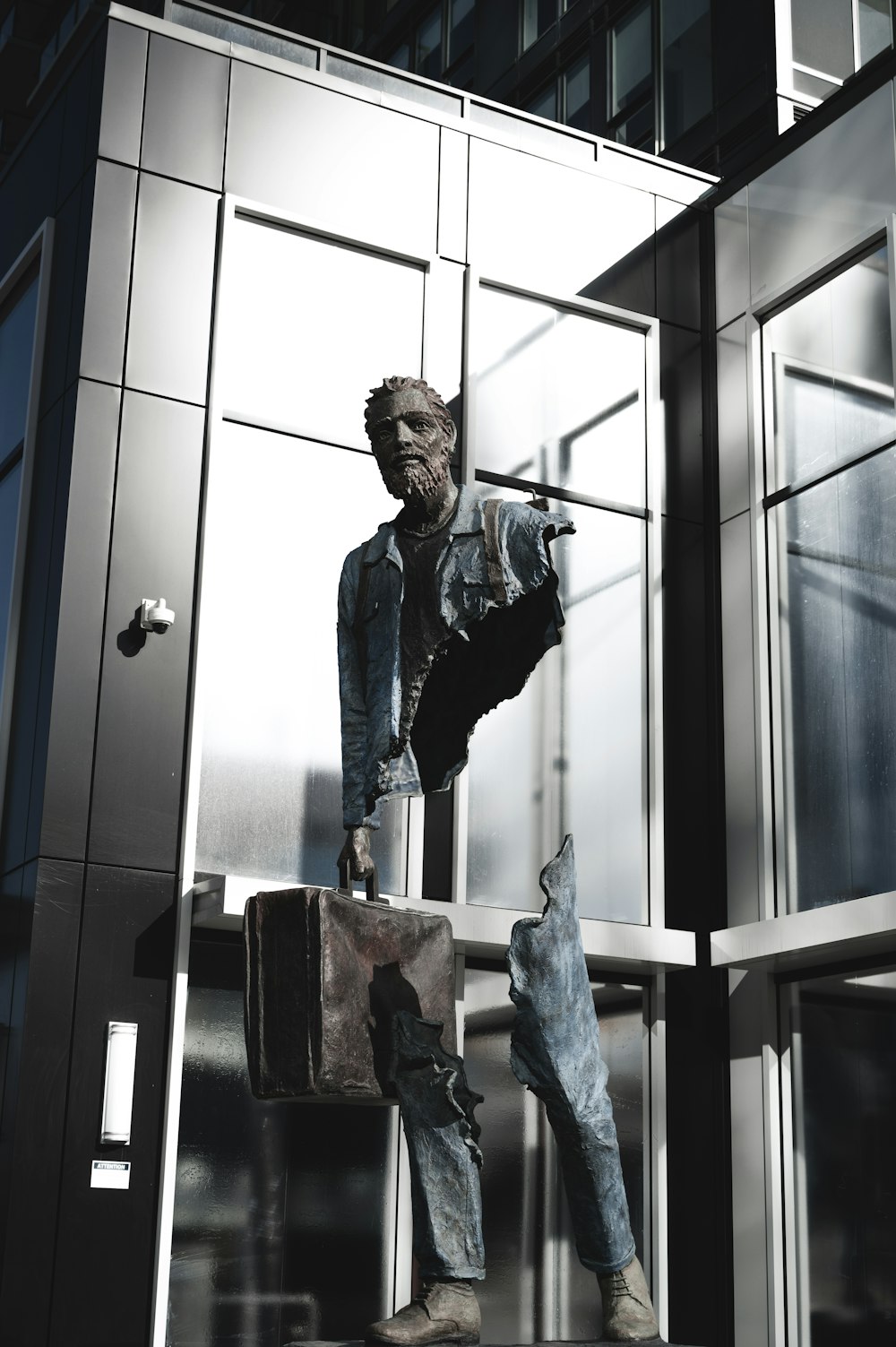 man in blue denim jacket standing beside blue wooden door