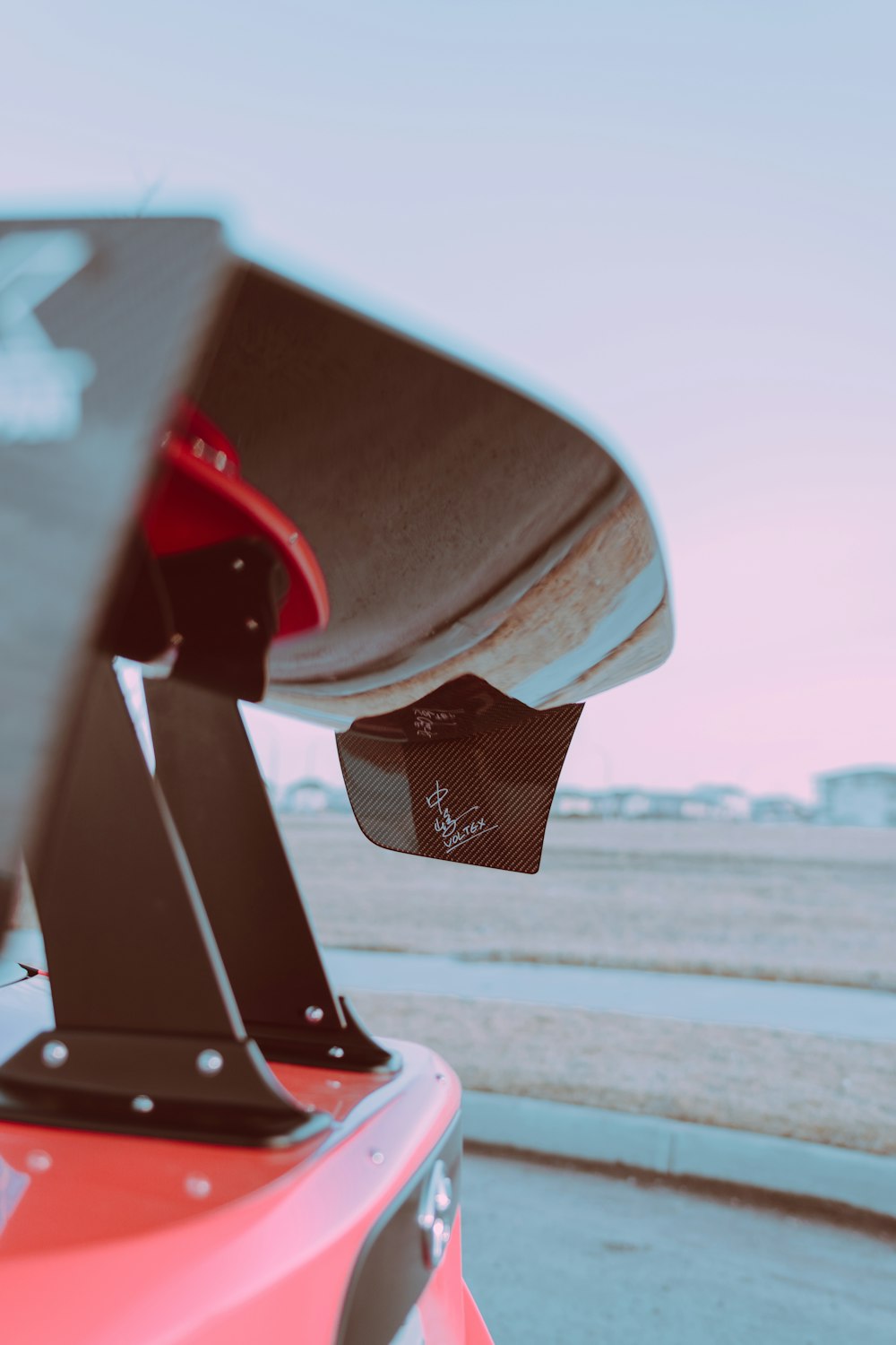 skateboard rosso e nero sulla strada di cemento grigia durante il giorno