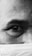 A detailed close-up of an individual's eye and eyebrow is visible, with the skin texture and fine lines accentuated. The lower part of the face is partially covered by a surgical mask, contributing to the foreground elements.