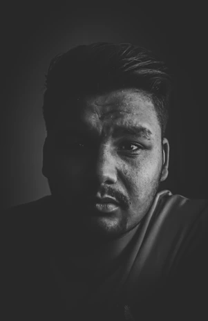 Close-up of a sharp fade haircut with clean lines under moody lighting.