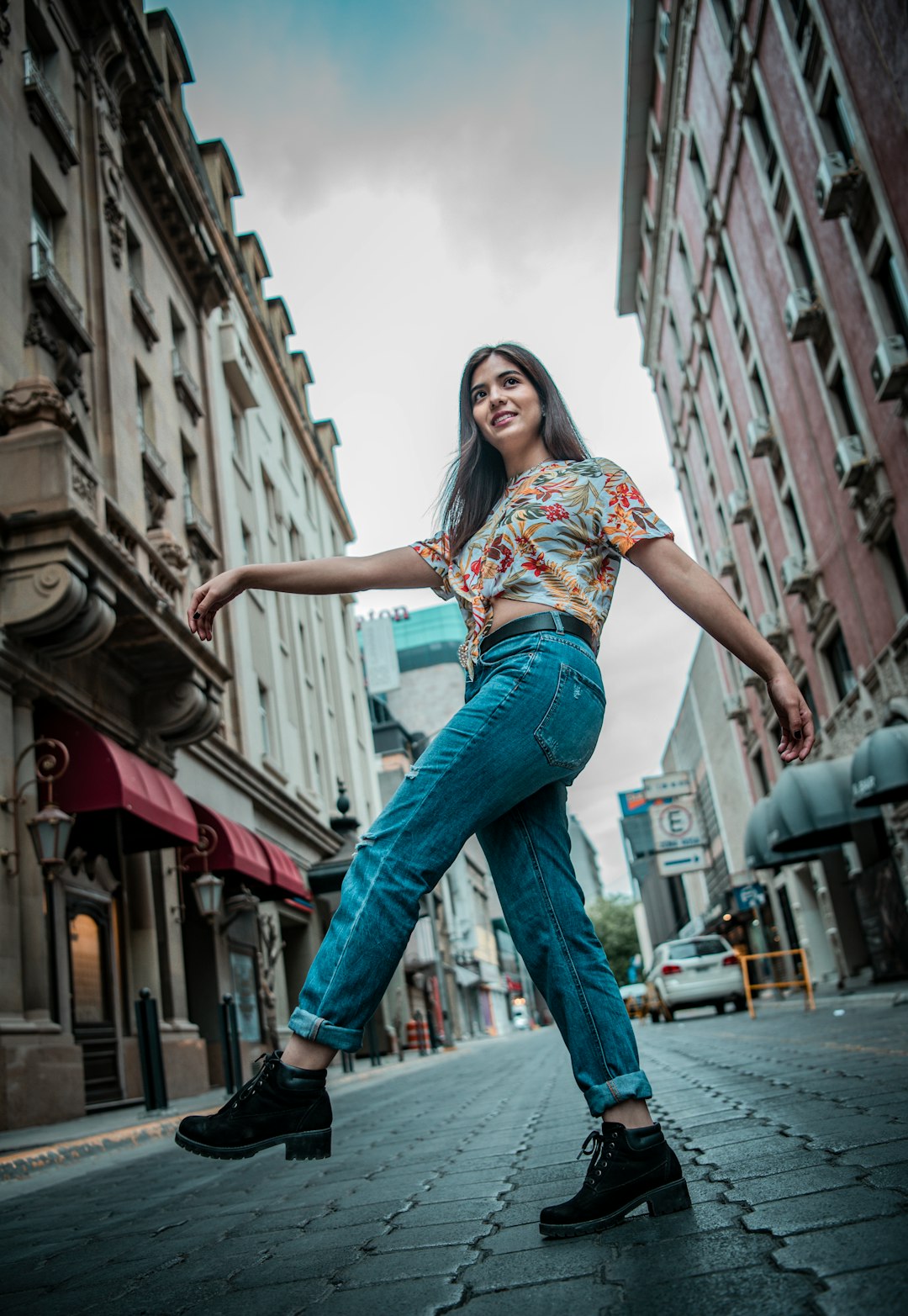 woman in blue denim jeans standing on the street during daytime