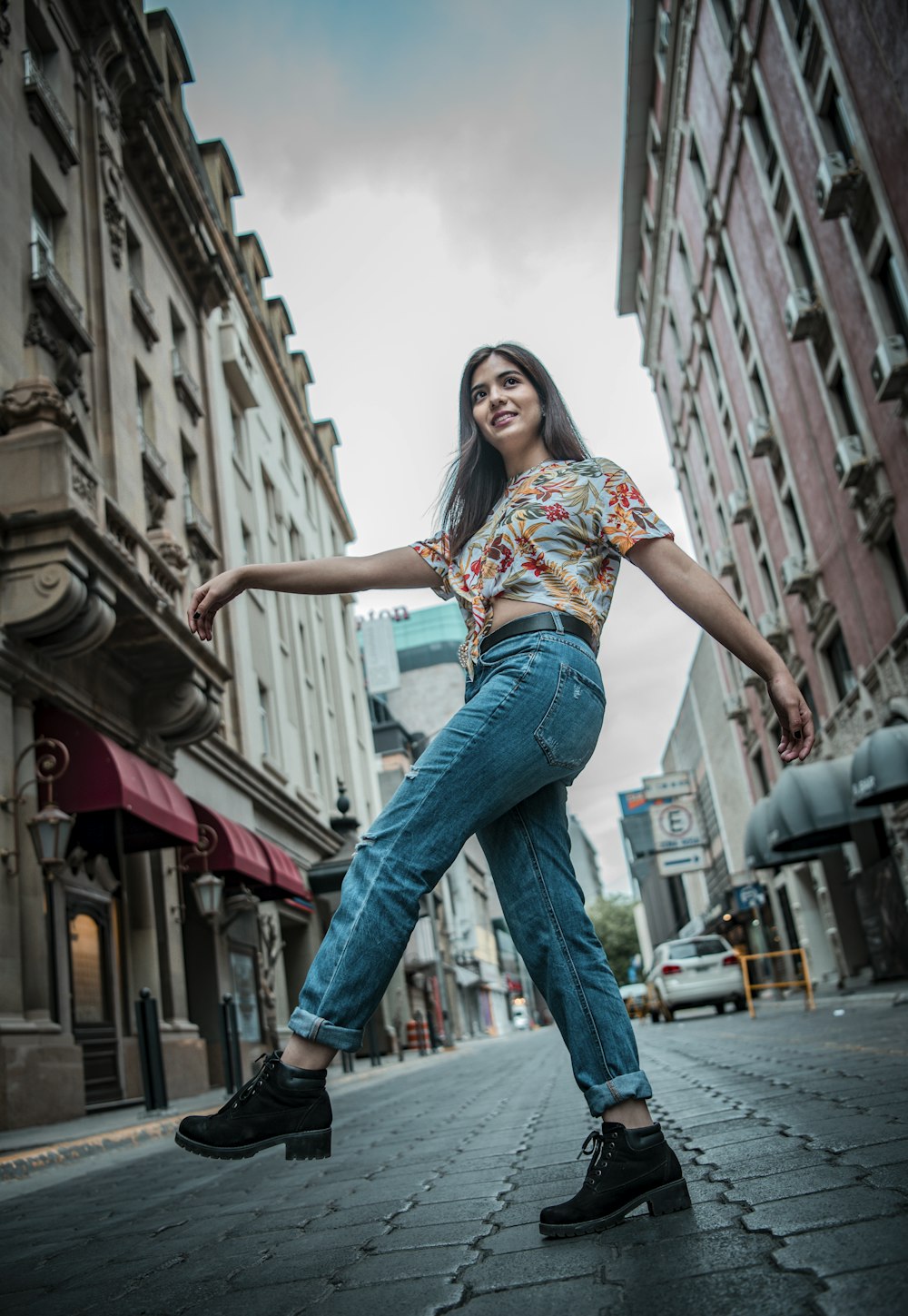 woman in blue denim jeans standing on the street during daytime