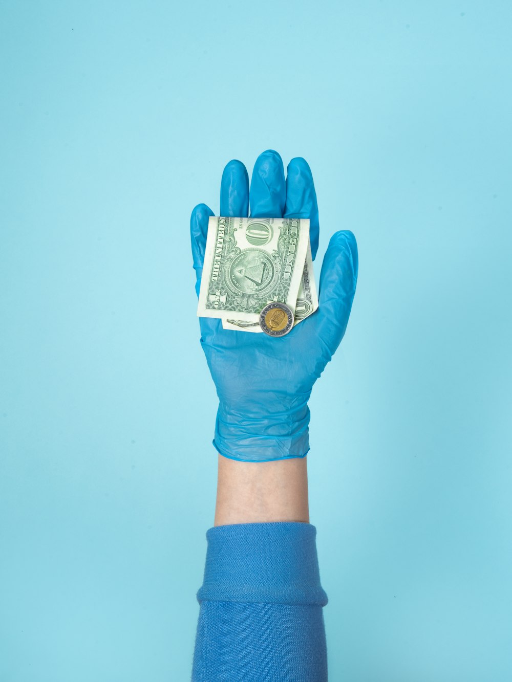 person in blue gloves holding 1 us dollar bill