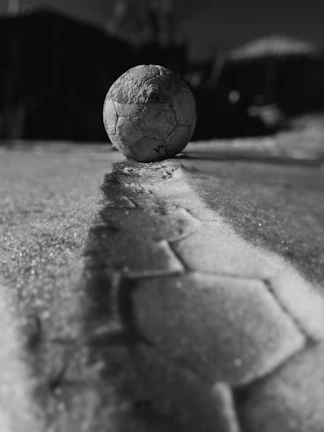 A dynamic shot of a soccer ball next to a pair of cleats and a discounted price sign in the background