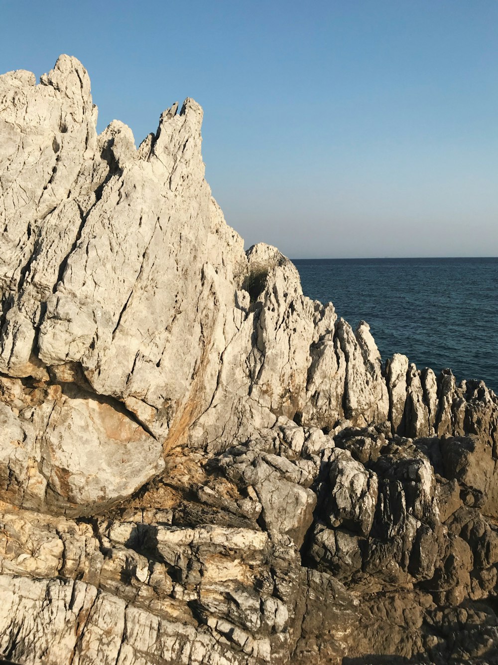 Formación de rocas grises cerca del cuerpo de agua durante el día