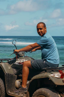 Riders enjoying a thrilling ATV ride along the shoreline with waves crashing nearby.