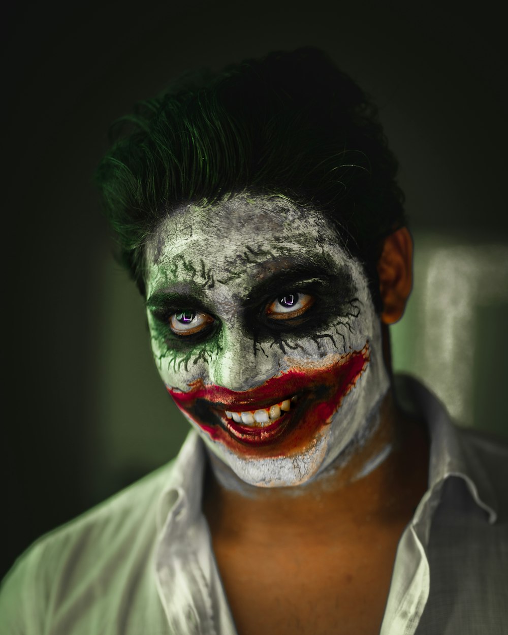 man in white collared shirt with red and green face paint