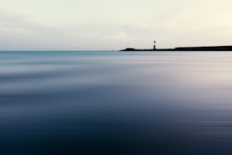 A serene lighthouse guiding through a foggy sea.