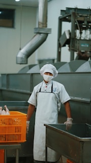 man in white chef uniform holding gray metal pipe