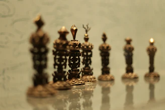 Elegant classical Roman-inspired chess pieces arranged on a marble table with the Colosseum softly blurred in the background.