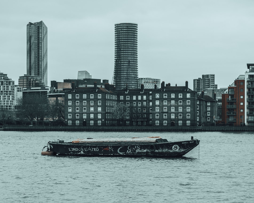 black and white boat on water near city buildings during daytime