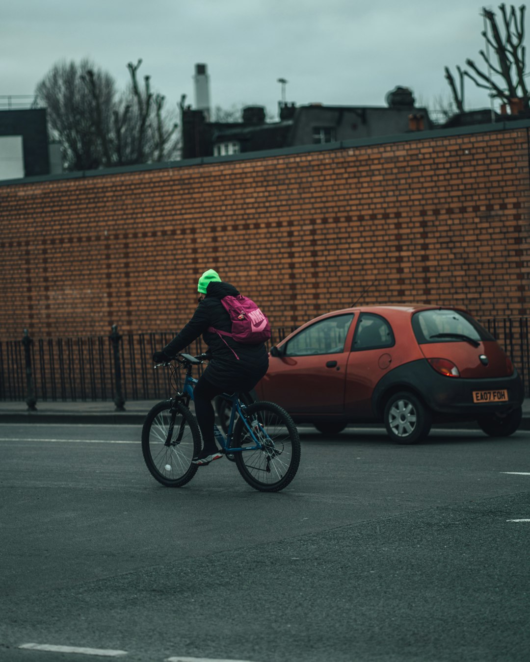 man in purple jacket riding bicycle on road during daytime