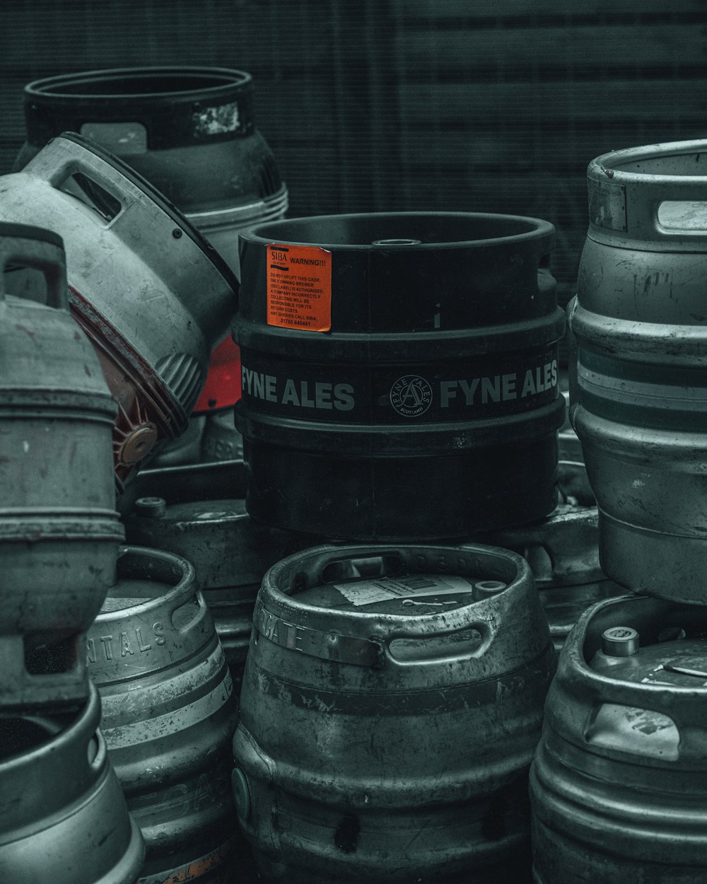 black plastic barrels beside gray car