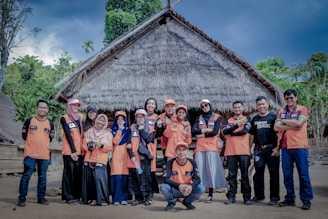 group of people standing near brown wooden house